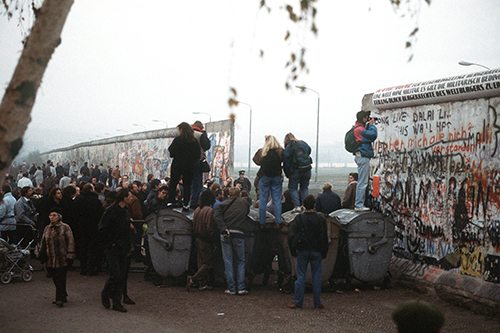 An image of people around a broken Berlin Wall